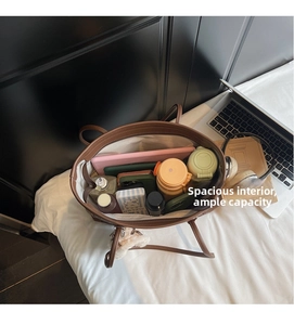 Interior view showing the large capacity of the brown leather tote bag with tech devices