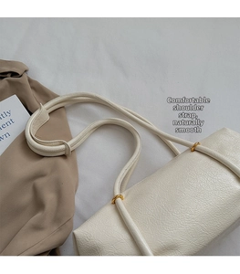Close-up of cream white Boston bag showing cracked texture leather and gold metal ring