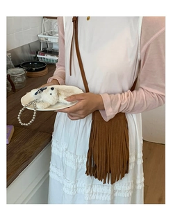 Détail du sac seau à franges marron foncé avec porte-clé en peluche en forme d'ours