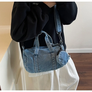 Dettaglio della borsa a secchiello in denim blu con tracolla e mini portamonete coordinato