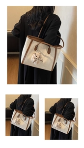 Detail of woven straw tote bag with brown leather trim and plush hamster charm