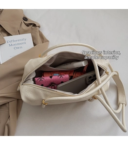 Macro detail of the spacious cream white hobo bag interior showing daily essentials storage
