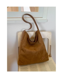 Détails de texture du sac hobo en daim marron avec coutures minimalistes et bandoulière en cuir