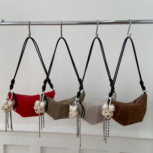 Détail de quatre sacs demi-lune en daim colorés avec surpiq coutures et breloque d'ours