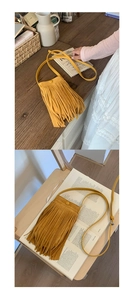 Détail du sac bandoulière bohème en daim jaune avec de longues franges