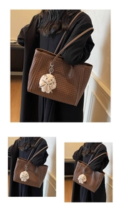 Detail of dark brown woven leather tote bag with a white plush bunny charm on shoulder