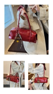 Detail of burgundy Boston bag showing oil-wax leather texture and stylish charms