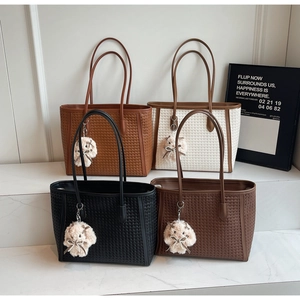 Detailed view of woven texture tote bags in four colors with cute plush doll charms