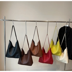 Six colors of minimalist pebbled leather tote bags hanging on a metal rack display