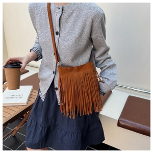 Vue détaillée du sac bandoulière en daim marron avec texture à longues franges