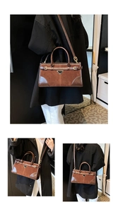 Close-up of brown vintage suede and leather handbag with signature triangle metal plaque