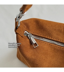 Detail view of silver metal zipper on brown suede vintage dumpling bag