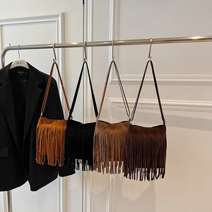 Sacs seaux en daim chic avec longues franges en quatre couleurs sur un support mural