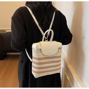 Detail of a minimalist woven straw backpack with beige contrast textures on a model