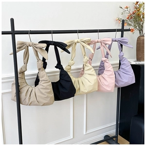 Detail view of colorful ruched shoulder bags with stylish bow accents in five pastel shades