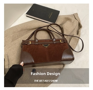 Detail of dark brown suede and leather splicing handbag with triangle metal plaque
