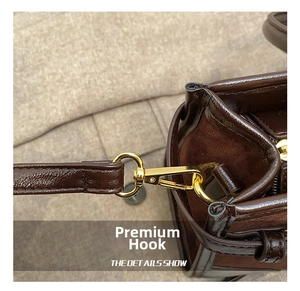 Detail of high-quality golden metal hook and brown leather texture on a tote bag