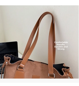 Detail showing high-quality stitching on brown suede tote handles and silver metal hardware