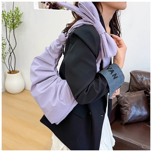 Detail view of a lavender ruched cloud bag with lightweight shiny fabric and crescent design