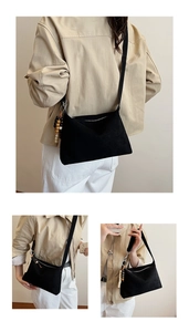 Detailed views of a black retro dumpling crossbody bag worn by a model in khaki.