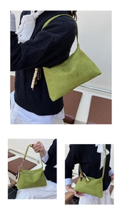 Close-up detail of the green suede underarm bag featuring a vintage wooden bead charm
