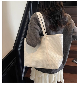 Detail of white woven leather tote bag showing intricate texture and luxury craftsmanship