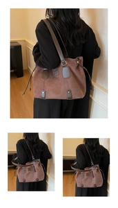 Close-up of brown suede tote bag featuring premium leather trim and side drawstring detail
