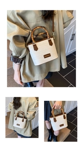Close-up of white woven bucket bag featuring natural bamboo handle and gold logo plate