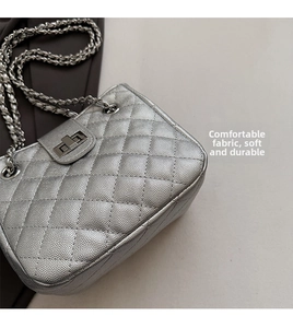 Detailed macro of silver quilted caviar leather handbag with metallic chain strap