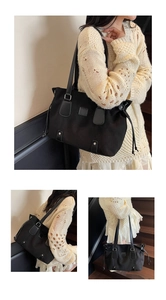 Close-up of black canvas tote bag with leather trim details and side drawstring feature