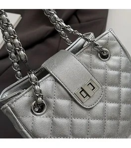 Close-up of silver quilted caviar leather bag with metallic chain strap and twist-lock