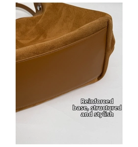 Detailed view of reinforced bottom and contrast stitching on large suede tote bag
