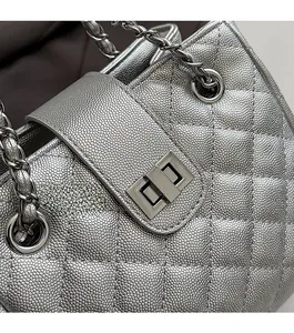Close-up of metallic silver quilted bag showing the classic turn-lock and leather chain