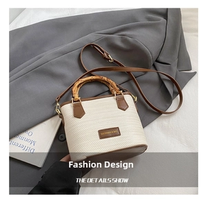 Detailed macro view of woven cream bucket bag with bamboo handle and leather trim