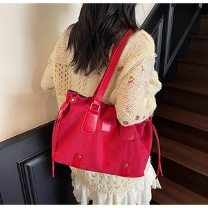 Detailed side view of a vintage red suede tote bag with fringe tassels on model