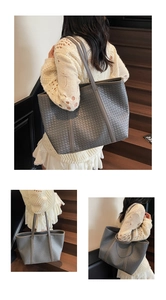 Close-up of large grey woven leather tote bag with Intrecciato pattern for daily commute