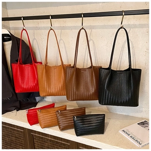 Détail de sacs cabas tissés et pochettes assorties en quatre couleurs classiques