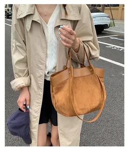 Chic brown suede patchwork tote bag styled with an autumn trench coat and baseball cap