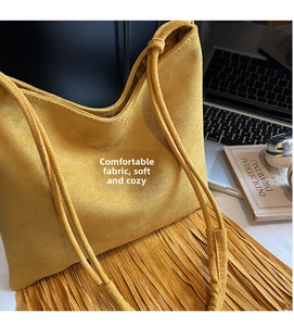 Detalle del bolso bandolera de ante amarillo con flecos largos y estilo bohemio