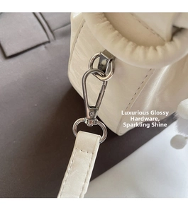 Detail of cream leather bag showing the silver metal hook and detachable strap connection