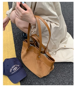 Detail of suede and leather patchwork tote bag with long shoulder straps in street view