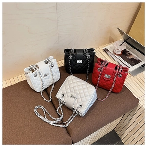 Detail of quilted leather bucket bags with metal chain straps and twist-lock closures
