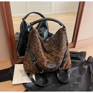 Close-up of leopard print tote bag with black leather handles and silver metal hardware