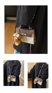 Detailansicht einer braunen Vintage-Handtasche mit einem niedlichen Teddybär-Anhänger