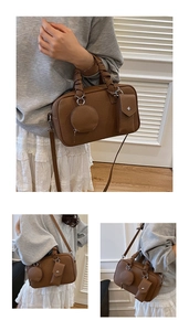 Dettaglio della borsa Boston in pelle testa di moro con manici intrecciati e mini pochette