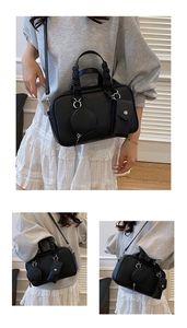 Dettaglio borsa Boston in pelle nera con mini pochette e manici intrecciati chic