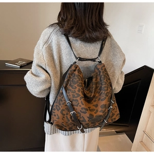 Detail of leopard print canvas backpack showing the large capacity and leather trim details