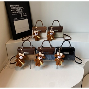 Detailansicht koreanischer Mini-Handtaschen mit niedlichen braunen Teddybär-Anhängern