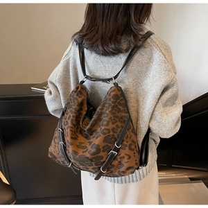 Detailed view of leopard print hobo bag with adjustable leather strap on model
