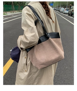 Back view of a large two-tone patchwork tote bag worn with a stylish khaki trench coat